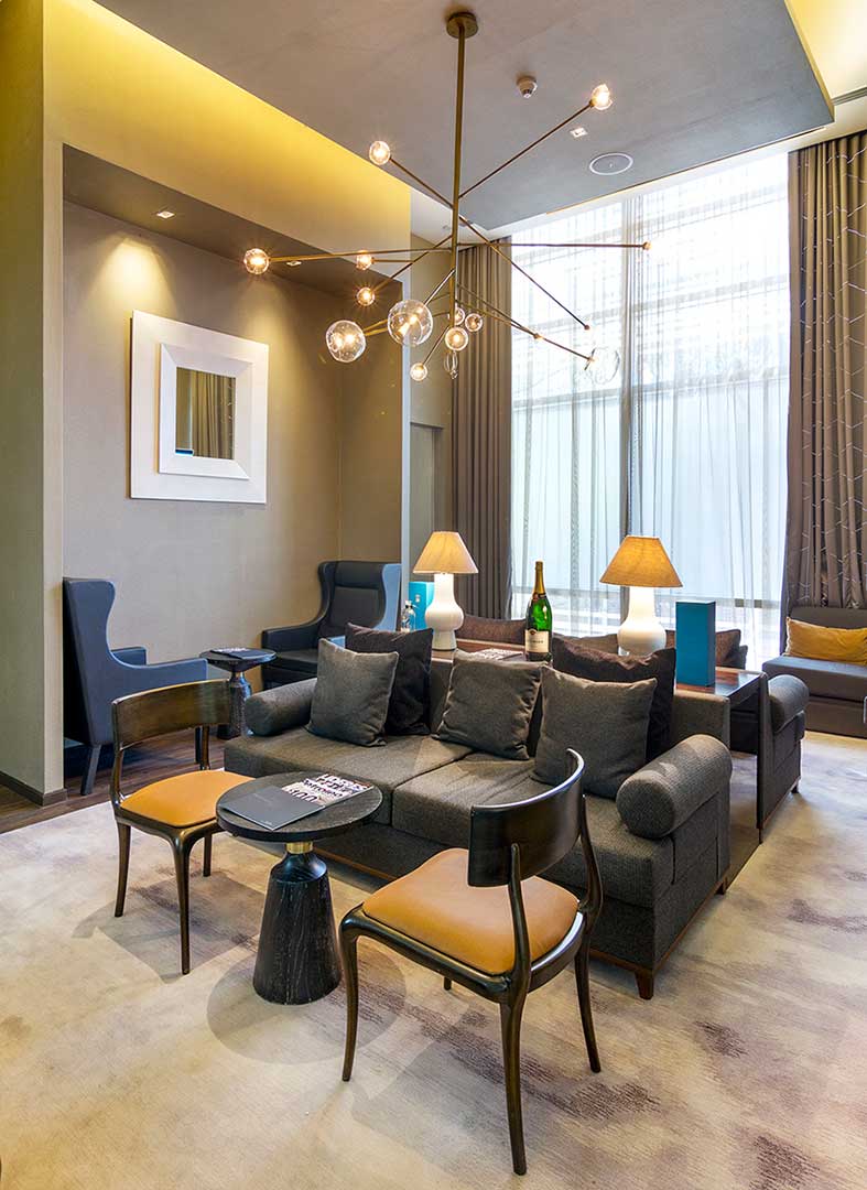 Recibidor con muebles de diseño Club Potentia en Hotel St. Regis. Muebles de encino al alto brillo y tela cuero creados por Depa 102